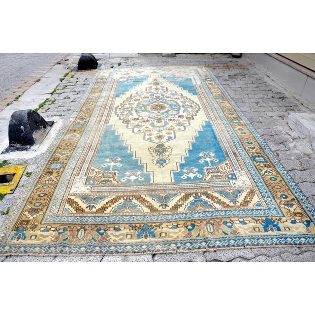 This is a vintage Turkish Oushak rug from the 1960s. The piece was hand-knotted.