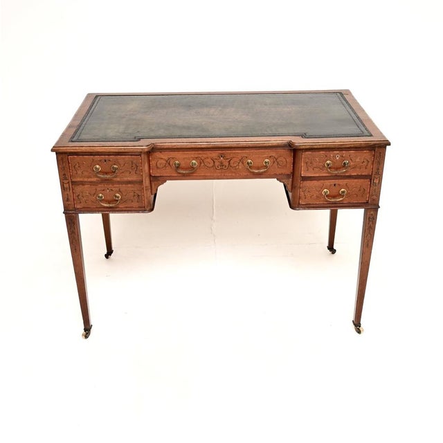 A beautiful antique Edwardian inlaid leather top desk, made in England and dating from around the 1900-1910 period. This...