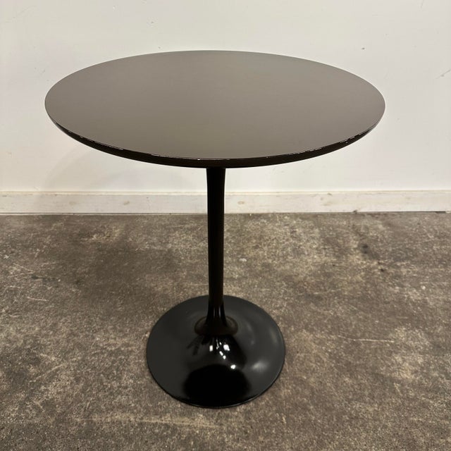 Mid Century Modern Burke Round Tulip Bistro Table. This table features a metal tulip base with a laminate covered top made...
