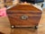 Small mahogany tea caddy of rectangular form with a hinged, faceted lid outlined by simple line inlay. The lid opens to a...