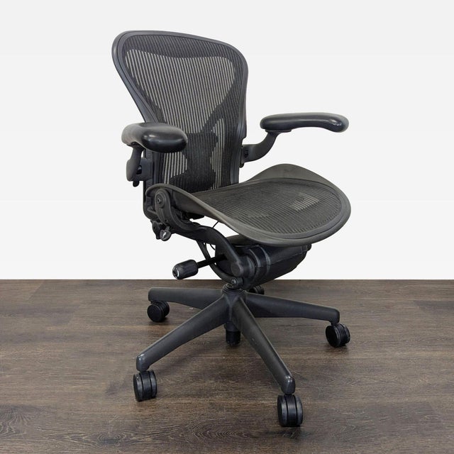 This Herman Miller Aeron chair offers comfortable, ergonomic support with its breathable black mesh seat and back....