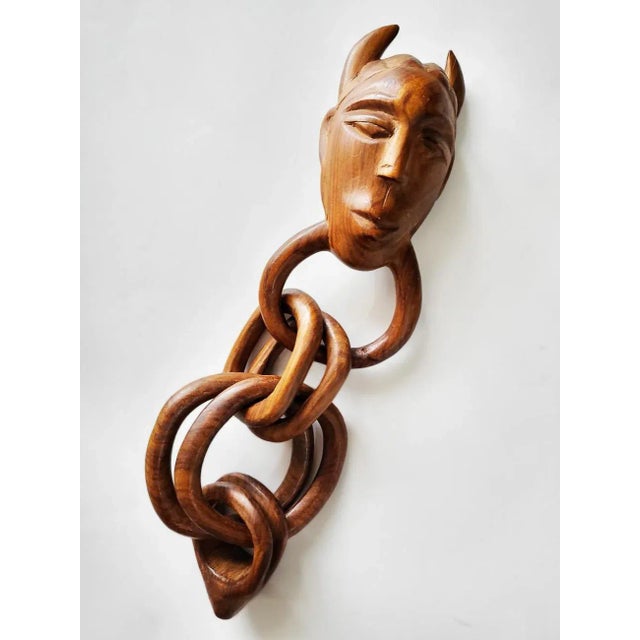 There's a lot to unfold here. The magic of this piece is that it's carved from one piece of teak wood. Each ring of the...
