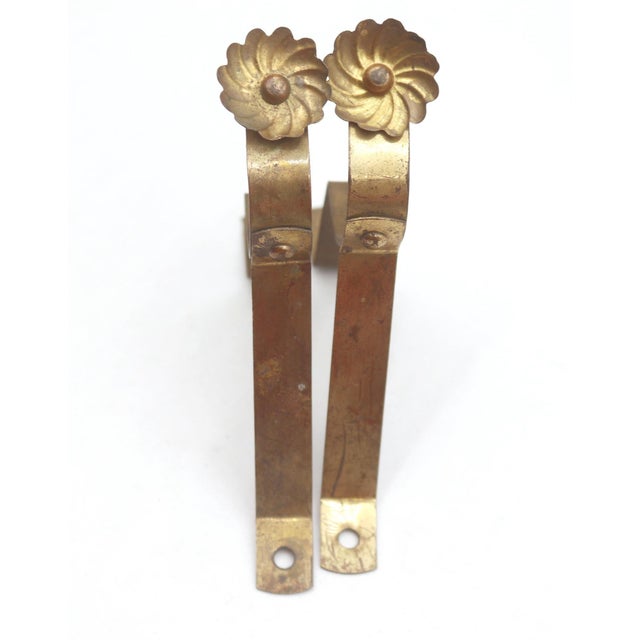 Vintage curtain rod brackets made of brass with floral screw heads. The original mounting screws are not available. Good...