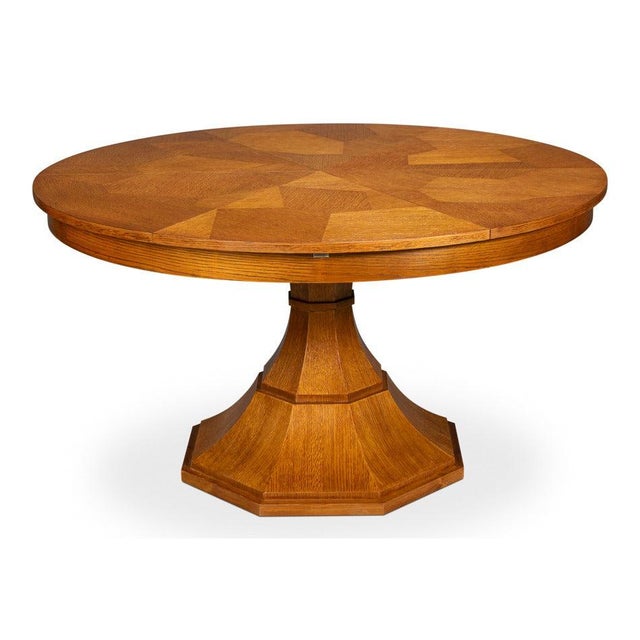 Warm-toned oak and a faceted column bring geometric structure to the dining room. A single faceted pedestal tapers from a...