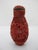 Vintage Chinese carved red cinnabar snuff bottle with a fitted brass-lined top, featuring an intricate floral motif and...