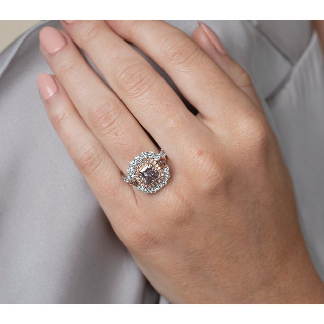 Dazzle and impress with this radiant cut 1.60 carat GIA-certified fancy dark brown pink diamond ring. Stationed in 18k...