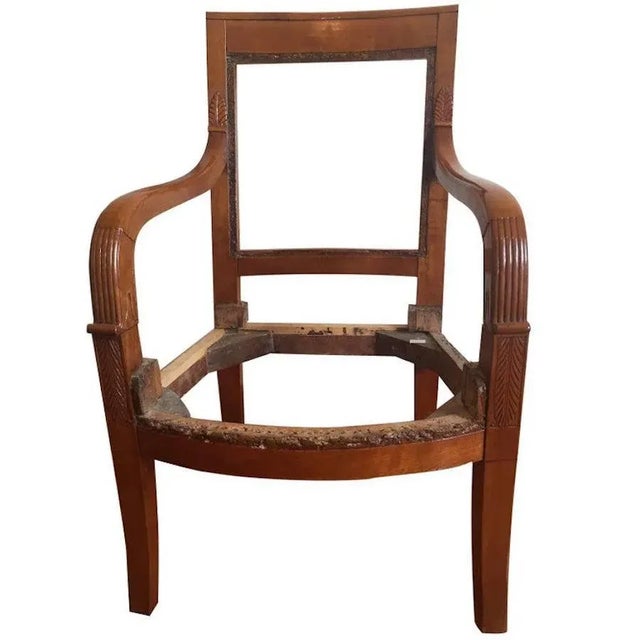 Fine quality French Empire cherrywood armchairs. Carved arms in shallow relief with acanthus leaves, elegant saber legs,...