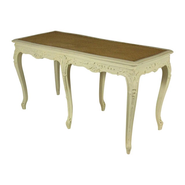 A late 19th-C. French Louis XV style painted bench with hand carved details and caned seat.
