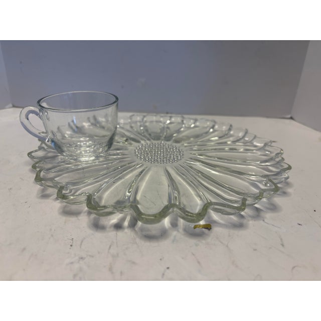 A refined mid-century pressed glass snack set consisting of four sculptural daisy-pattern plates paired with four matching...