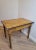 A heavily worn and distressed hand painted yellow faux wood grain farmhouse kitchen work table. Hand-crafted of solid...