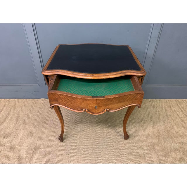 A good 19th century French walnut flap table. Of serpentine form and fitted with a sumptous black leather writing surface....