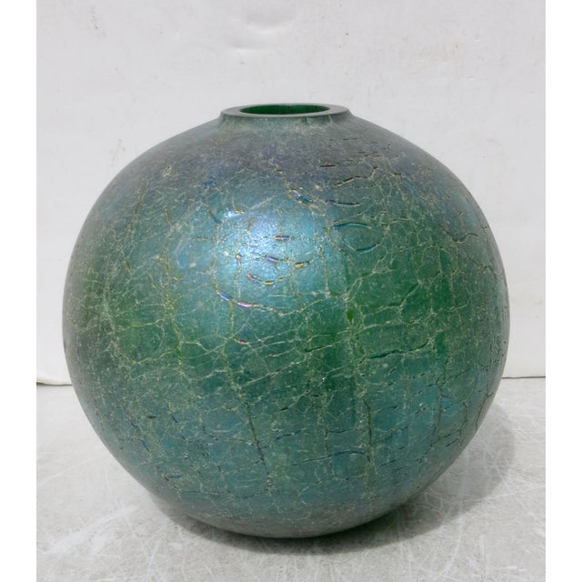 Cast glass green globe with crackle texture and blue-green, red flash surfaces. The globe is bottle green, with a surface...
