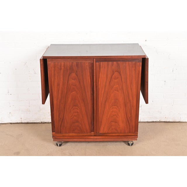 A sleek and stylish Mid-Century Modern rolling extending bar cart or buffet server cabinet By Jack Cartwright for Founders...