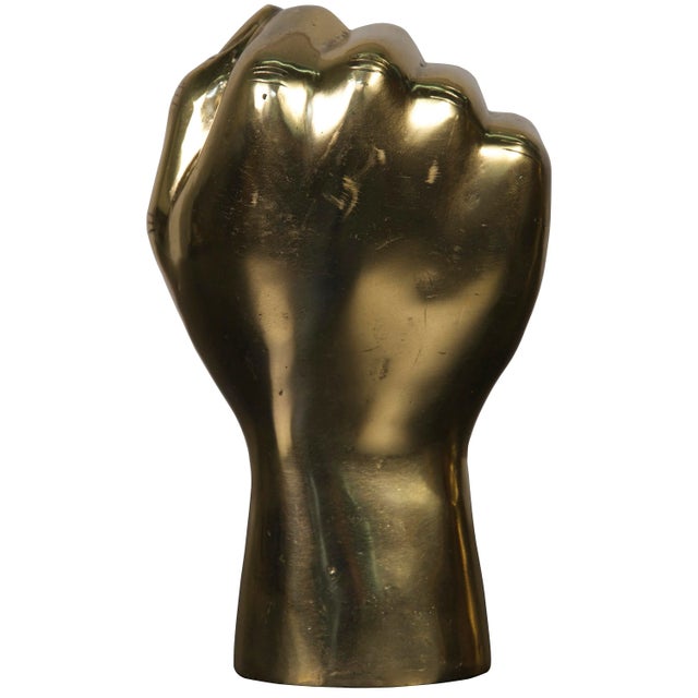 A closed fist, raised proudly, is rendered simply in an expertly weathered warm antique finish. Featuring raw, stylized...