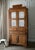 An authentic, solid wood country cabinet featuring a hand-carved scalloped crest, gathered fabric upper doors with no...