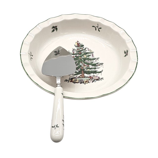 A ceramic dish made for holiday sweetness, with scalloped rim edged in green and the evergreen tree at its heart. Around...