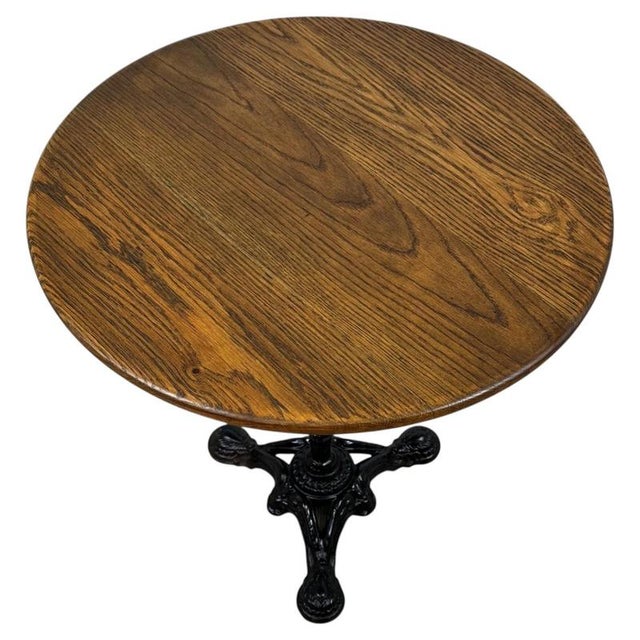 A striking vintage 20th-century side table, combining a beautifully detailed cast iron base with a substantial circular...