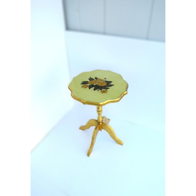 A gold giltwood scalloped side accent table with a floral top, in the French Provincial design style, circa late 20th to...