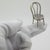 This vintage silver decorative object depicts a traditional rustic chair with a woven straw seat miniature, crafted as a...