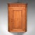 This is an antique mounted corner cabinet. An English, golden oak and mahogany wall cupboard with inlaid shell motif,...