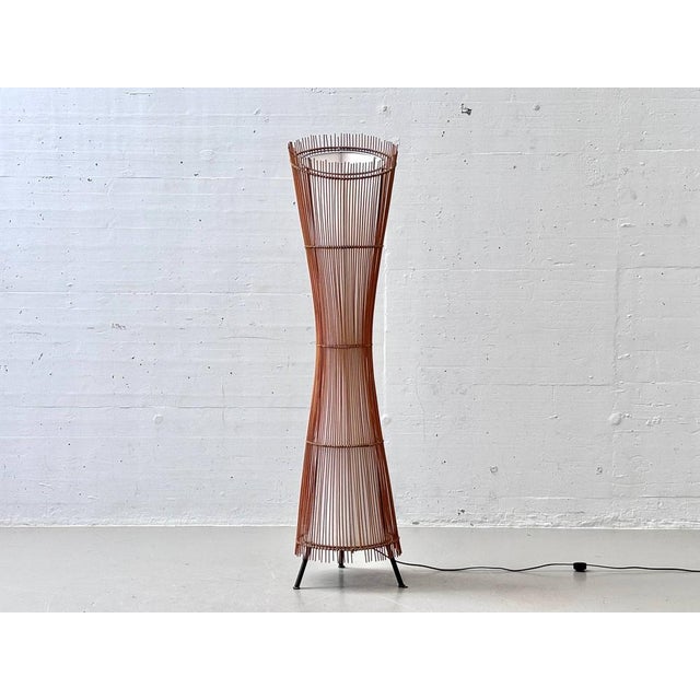 A striking French floor lamp from the 1960s/70s with a sculptural hourglass shape and a delicate construction of dark-...