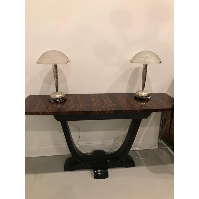 A pair of French Art Deco table lamps signed by the French artist Charles Schneider. The shades are enhanced by geometric...