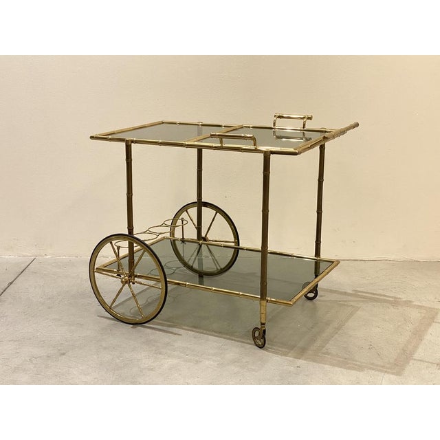 Maison Baguès bar trolley from the 70s, brass worked with imitation bamboo, removable tray, smoked glass tops, height of...