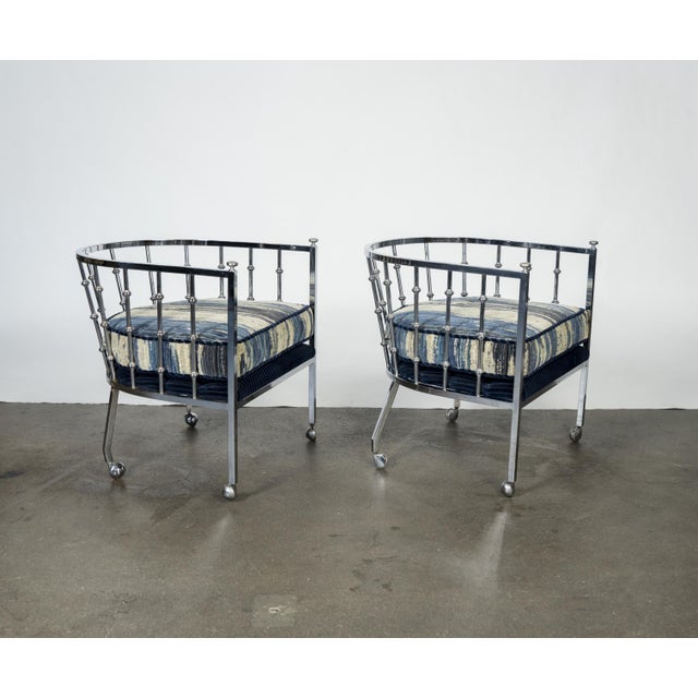 Sculptural chrome barrel-form lounge chairs with cylindrical frames, vertical spindle detailing, and upholstered cushions....