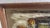A textural, richly-toned vintage oil painting rendered entirely with a palette knife, capturing a shadowed hacienda...