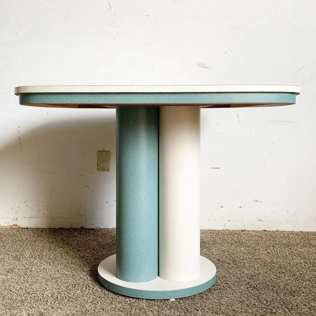Step into the vibrant world of postmodern design with this striking Teal and White Laminate Dining Table. This unique...