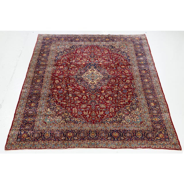 This Vintage Kashan Hand-knotted wool rug with the red field this rug has multicolor accents. This rug measures 9'8'' x...