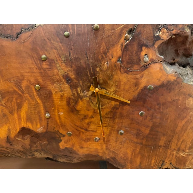 This monumental wall clock is hand-carved from a single slab of richly figured burl wood, presenting dramatic natural...