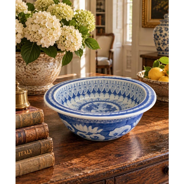 A classic large Chinoiserie blue and white porcelain bowl with painted koi fish which are balanced with a crisp border...
