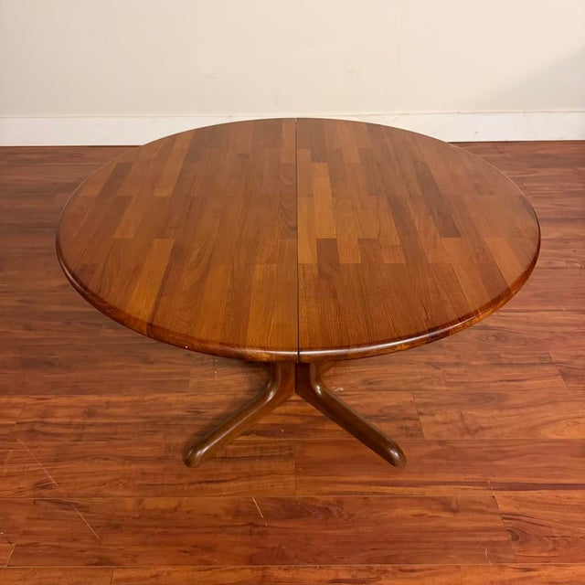 Vintage Danish modern solid teak dining table with split pedestal base. It seats four comfortably round and six with the...