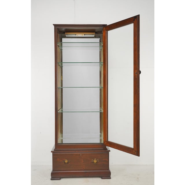 Vintage Traditional style curio display cabinet with a dark stained wood frame, a mirrored back, four adjustable glass...