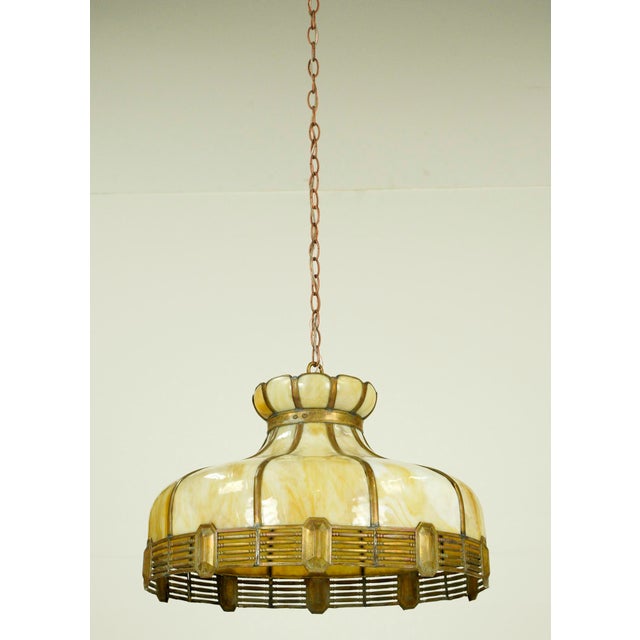 Vintage stained glass pendant light in a mixed tan and white color scheme with an antique brass chain. This requires one...