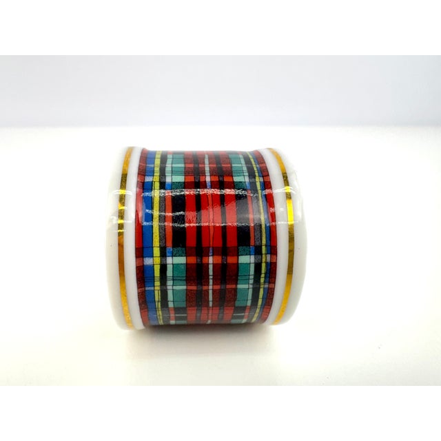 A festive set of eleven vintage porcelain napkin rings featuring a classic tartan plaid in rich red, green, blue, black,...