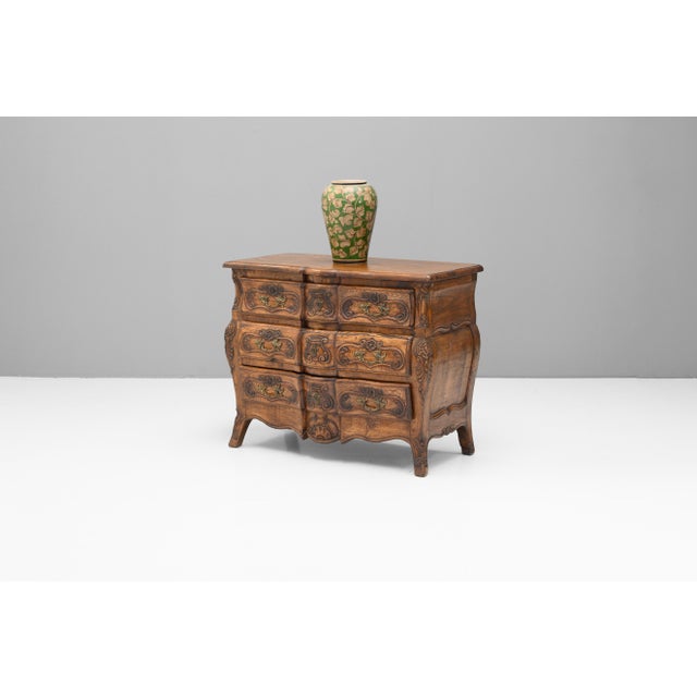 French bombe commode in walnut with carved drawer fronts and original brass handles. Circa 1950.