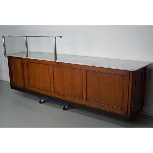 This shop counter was made around the 1920s in Germany mainly in oak and oak veneer with a marble top and glass windows....