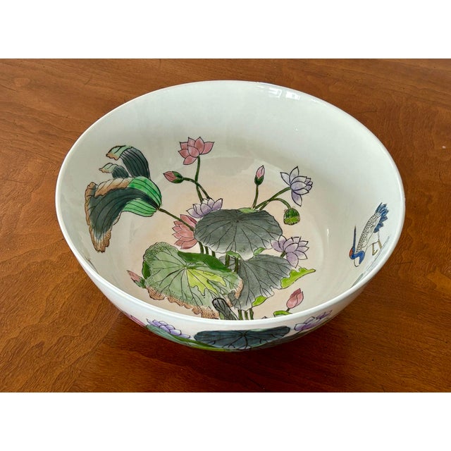 Vintage Chinese porcelain bowl, hand-painted with elegant lotus flowers and cranes on both its interior and exterior. In...
