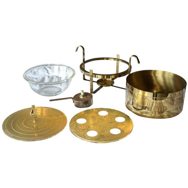 A Mid-Century Modern chafing dish designed by Tommi Parzinger and made by Dorlyn Silversmiths. Brass with a glass insert.