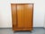 Vintage 1960s oak wardrobe with splayed legs, offering ample storage: two sliding doors and two drawers with gold handles....