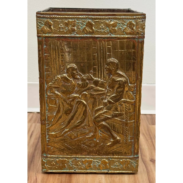Crafted in France and rectangular in shape, the wood and brass waste bin is decorated with a repousse figural scene to...