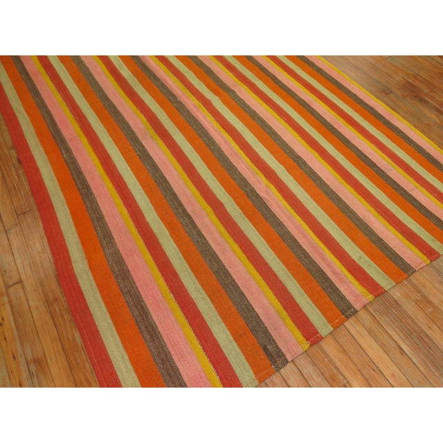 20th century Turkish Kilim with a striped motif in orange, pinks, reds, yellows, teal and brown.