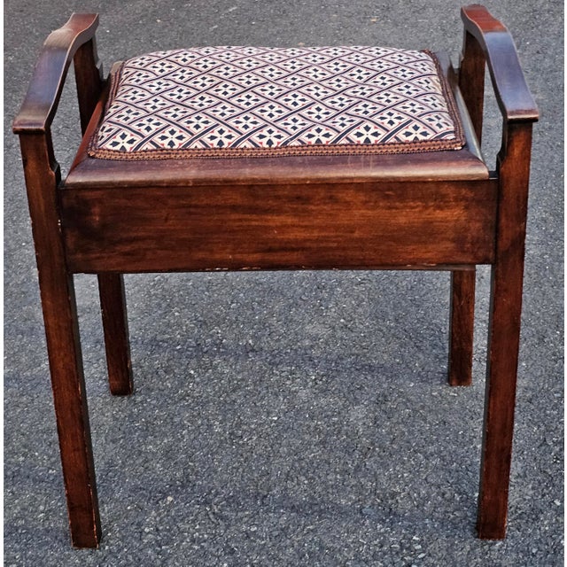 A late Victorian Walnut Piano Stool featuring a lift-up seat that reveals a built-in compartment for storing sheet music....