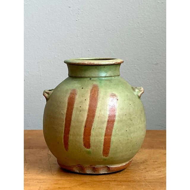This vase presents a full, rounded body that swells generously outward before narrowing through a defined shoulder to a...