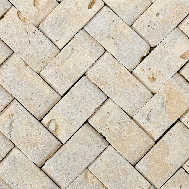 Honed and unfilled coralina travertine 1" x 2" dimensional herringbone decorative mosaic tile. Suitable for use in...