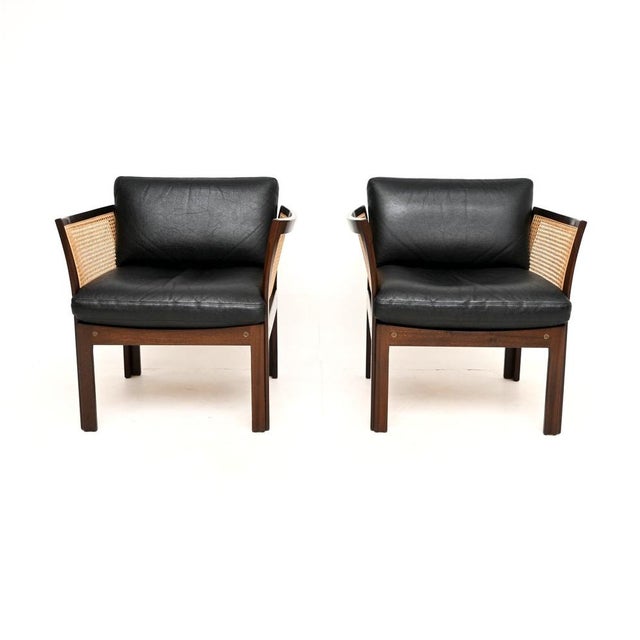A stylish and very rare pair of vintage Danish cane and leather armchairs by Illum Wikkelso. This model is called the...