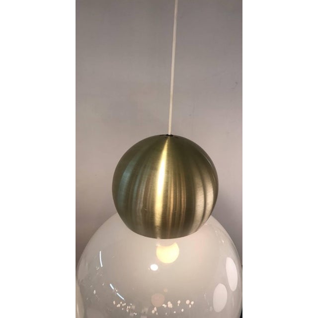 A 1970s modern design pendant light by well-known Italian lighting company Stilux of Milano. The white opaline shade is...