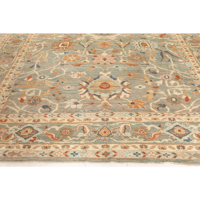 This Sultanabad-inspired rug features a soft, muted steel-blue field richly adorned with an all-over pattern of stylized...
